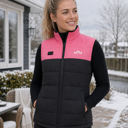 Vrouw met roze KingsPower verwarmde bodywarmer in winterse tuin